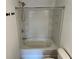 A bathtub and shower combination with white tiling and storage shelves at 3015 Liberty Nw Way, Atlanta, GA 30318