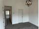 A carpeted bedroom illuminated by a modern light fixture with an adjacent hallway view at 3015 Liberty Nw Way, Atlanta, GA 30318