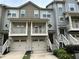 Townhome exterior featuring a two-car garage, balcony, and a landscaped front yard at 3015 Liberty Nw Way, Atlanta, GA 30318