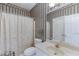 Classic bathroom featuring patterned wallpaper, white vanity, toilet, and a tub with a shower at 3871 Lake Juliette Dr, Buford, GA 30519