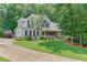Charming home featuring a covered front porch, beautiful lawn, and mature trees at 3871 Lake Juliette Dr, Buford, GA 30519