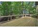 A wooden deck with railings overlooks a wooded area, providing a private outdoor space at 545 Woodman Pl, Roswell, GA 30076