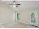 Bright bedroom featuring neutral walls, carpet floors, modern fan, and access to balcony at 545 Woodman Pl, Roswell, GA 30076
