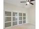 Bright bedroom featuring neutral walls, carpet floors, modern fan, and closet with sliding doors at 545 Woodman Pl, Roswell, GA 30076