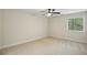 Neutral bedroom with carpet flooring, ceiling fan, and window letting in natural light at 545 Woodman Pl, Roswell, GA 30076