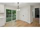 Bright dining area with hardwood floors, modern light fixture, and sliding glass doors to deck at 545 Woodman Pl, Roswell, GA 30076