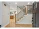 Bright entryway featuring hardwood floors, staircase with black iron railing and open view to kitchen at 545 Woodman Pl, Roswell, GA 30076