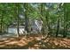 Charming two-story home with a gray exterior and a two-car garage nestled in a wooded lot at 545 Woodman Pl, Roswell, GA 30076