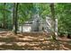 Charming two-story home with a gray exterior and a two-car garage nestled in a wooded lot at 545 Woodman Pl, Roswell, GA 30076