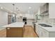 This kitchen features a large island, stainless steel appliances, custom cabinets and hardwood floors at 545 Woodman Pl, Roswell, GA 30076