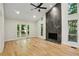 Bright living room with hardwood floors, large windows, and a modern fireplace at 545 Woodman Pl, Roswell, GA 30076
