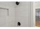 Updated shower features white tile and a modern black shower head at 545 Woodman Pl, Roswell, GA 30076