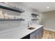 Finished basement with a wet bar featuring quartz countertops, modern faucet and floating shelves at 116 Archstone Sq, Mcdonough, GA 30253