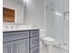 Modern bathroom with gray vanity, toilet and glass shower with white tile surround at 116 Archstone Sq, Mcdonough, GA 30253