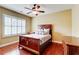 Comfortable bedroom with wood floors, ceiling fan, and natural light from shuttered windows at 116 Archstone Sq, Mcdonough, GA 30253