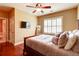Bright bedroom features wood floors, a ceiling fan, and an ensuite bathroom at 116 Archstone Sq, Mcdonough, GA 30253