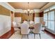 Elegant dining room featuring wainscoting, chandelier, hardwood floors, and window shutters at 116 Archstone Sq, Mcdonough, GA 30253