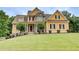 Charming two-story home featuring a well-manicured lawn, complemented by lush landscaping and a stone facade at 116 Archstone Sq, Mcdonough, GA 30253