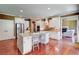Kitchen with stainless steel appliances, center island, and hardwood floors, open to living area at 116 Archstone Sq, Mcdonough, GA 30253