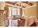 Cozy living room featuring coffered ceilings, large windows, and a stone fireplace at 116 Archstone Sq, Mcdonough, GA 30253