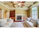 Inviting living room with coffered ceilings, stone fireplace, and built-in shelving at 116 Archstone Sq, Mcdonough, GA 30253