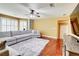 Bright living room has hardwood floors, a large sectional couch, and plantation shutters at 116 Archstone Sq, Mcdonough, GA 30253
