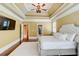 Sunlit main bedroom featuring tray ceiling and fan showcases access to the en suite bath and closet at 116 Archstone Sq, Mcdonough, GA 30253