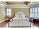 Stately main bedroom with a tufted headboard and bay window offers a bright and welcoming retreat at 116 Archstone Sq, Mcdonough, GA 30253