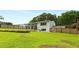 Large backyard with well-kept lawn, wooden fence, and back of house with sunroom at 1981 Shalimar Ne Dr, Atlanta, GA 30345