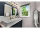 Modern bathroom with double sinks, stylish fixtures, and a window with a lush green view at 1981 Shalimar Ne Dr, Atlanta, GA 30345