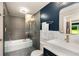 This bathroom features a soaking tub with glass door and showerhead, blue wall and modern fixtures at 1981 Shalimar Ne Dr, Atlanta, GA 30345