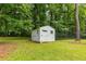 A white backyard shed stands neatly on the green lawn, offering extra storage space at 1981 Shalimar Ne Dr, Atlanta, GA 30345