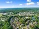 Expansive aerial view of a residential community with lush green trees, pool and tennis courts on a sunny day at 5157 Sunlake Dr, Hoschton, GA 30548