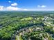 Aerial view of a neighborhood, surrounded by mature trees and lush greenery at 5157 Sunlake Dr, Hoschton, GA 30548