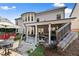 This backyard has a stone patio with outdoor seating, a grill, and a staircase leading to a higher level at 5157 Sunlake Dr, Hoschton, GA 30548