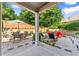 This backyard features a stone patio with a dining table, lounge chairs, and mature landscaping at 5157 Sunlake Dr, Hoschton, GA 30548