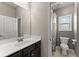 The bathroom features a toilet, shower and vanity with a large mirror and light fixtures at 5157 Sunlake Dr, Hoschton, GA 30548