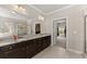 Bathroom showcasing a double vanity, walk-in shower, and view into the walk-in closet at 5157 Sunlake Dr, Hoschton, GA 30548