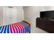 This bedroom features a bed with a red and blue comforter and a dresser with a TV on top at 5157 Sunlake Dr, Hoschton, GA 30548