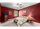 Cozy bedroom featuring a ceiling fan, natural light, and warm, inviting red walls at 5157 Sunlake Dr, Hoschton, GA 30548