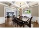 Elegant dining room featuring hardwood floors, coffered ceiling, and stylish chandelier, adjacent to an office space at 5157 Sunlake Dr, Hoschton, GA 30548