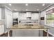 Bright kitchen features white cabinetry, granite countertops, and stainless steel appliances at 5157 Sunlake Dr, Hoschton, GA 30548