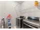 Functional laundry room with modern washer and dryer, shelving, and a vacuum cleaner at 5157 Sunlake Dr, Hoschton, GA 30548