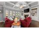 Bright living room with coffered ceiling, fireplace, built-ins, large windows, and hardwood floors at 5157 Sunlake Dr, Hoschton, GA 30548