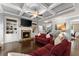 Cozy living room features a stone fireplace, built-in bookshelves, coffered ceiling, and hardwood floors at 5157 Sunlake Dr, Hoschton, GA 30548