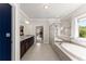 Bright bathroom with dual sink vanity, soaking tub and large window with natural light at 5157 Sunlake Dr, Hoschton, GA 30548