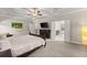Bright main bedroom features a ceiling fan, television, and access to the main bathroom at 5157 Sunlake Dr, Hoschton, GA 30548