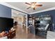 Open concept office with hardwood floors, custom shelving, and a view of the dining room at 5157 Sunlake Dr, Hoschton, GA 30548