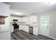 Bright kitchen featuring white cabinets, stainless steel appliances, and hardwood flooring at 52 Tide Water Way, Rockmart, GA 30153