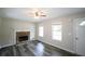 Cozy living room featuring a stone fireplace, two windows, and modern hardwood floors at 52 Tide Water Way, Rockmart, GA 30153